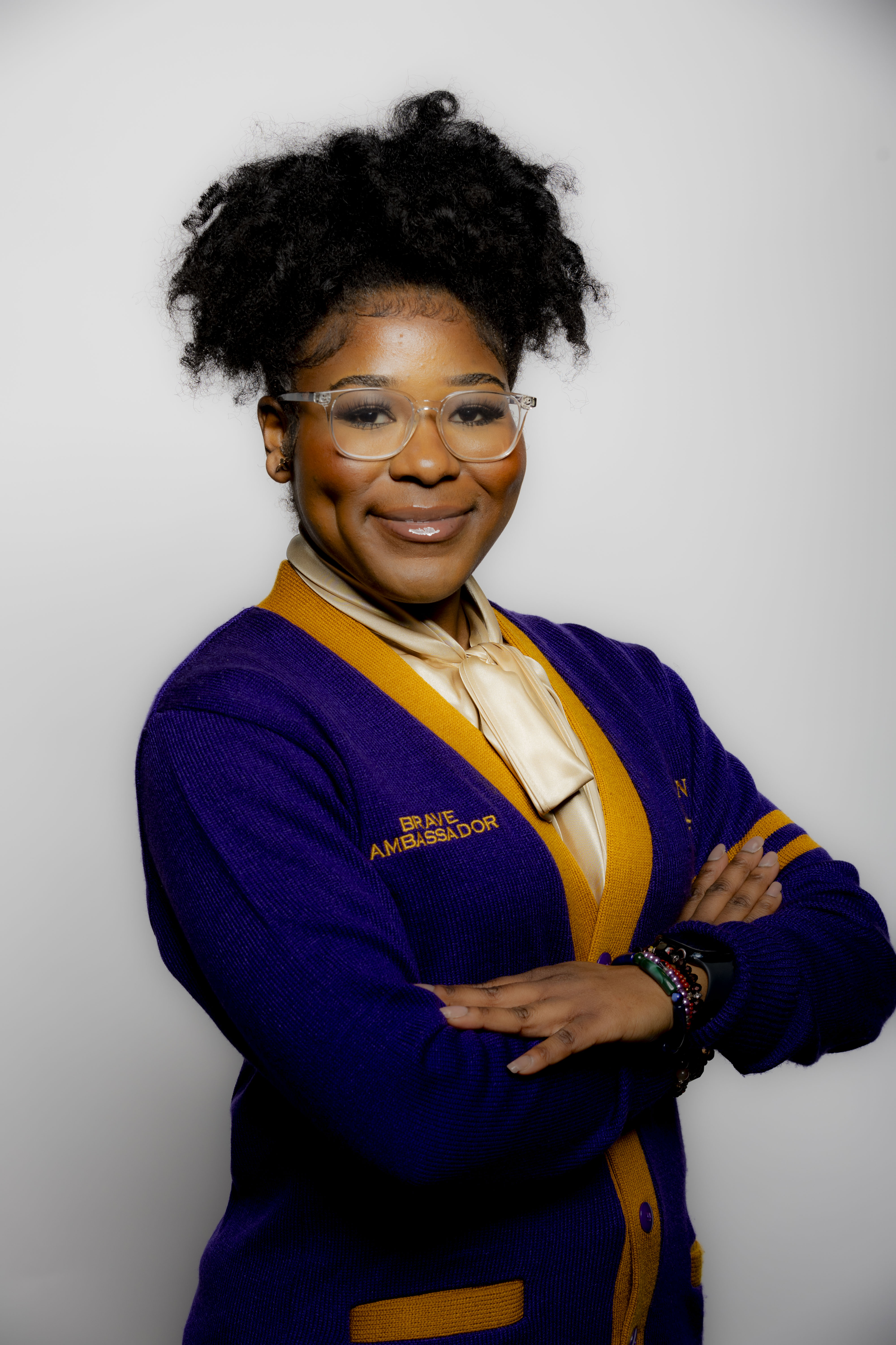 Professional portrait of Mersie Watkins wearing a purple cardigan.